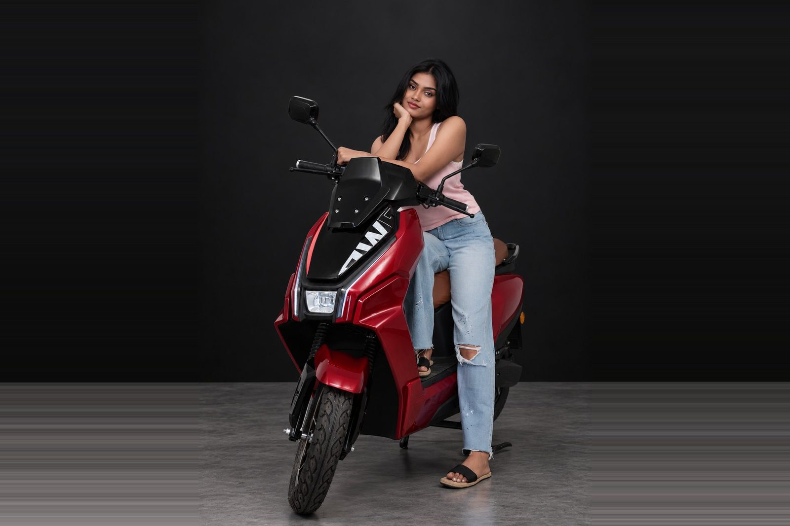 A rider leaning on a BNW electric scooter in red